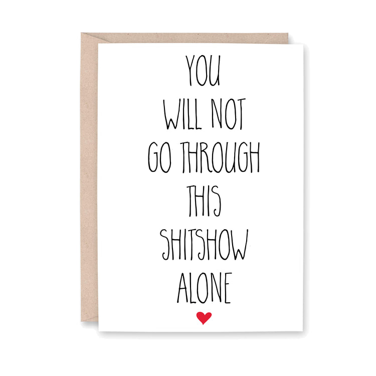 Greeting card with text 'You will not go through this shitshow alone' and a red heart on a white background.